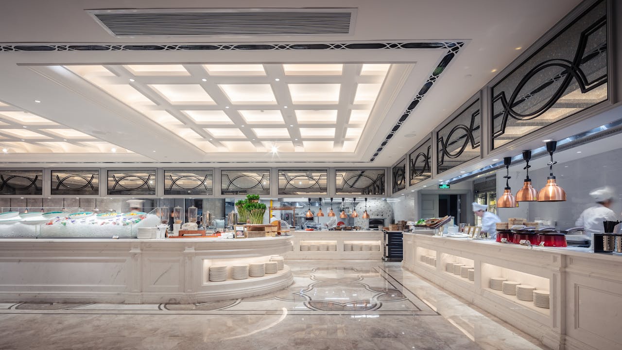 Luxurious hotel buffet display with modern interior design, stylish lighting, and culinary setup.